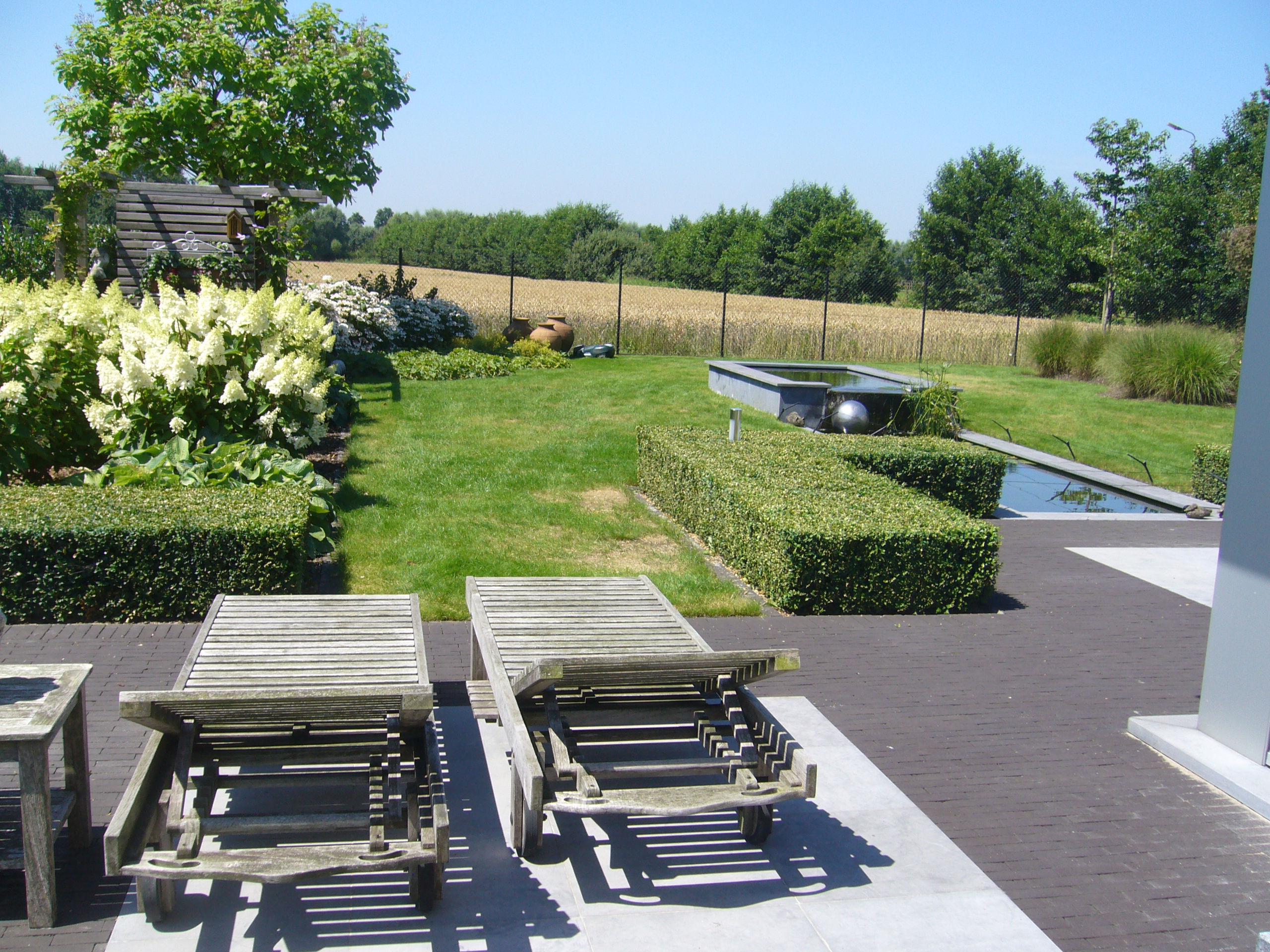 terras in blauwsteen met kleiklinker vijver landelijke tuin